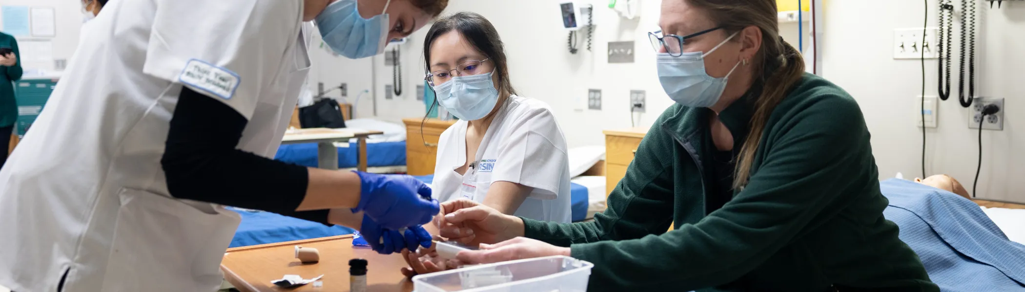 Trent University nursing students practice and learning with professor.