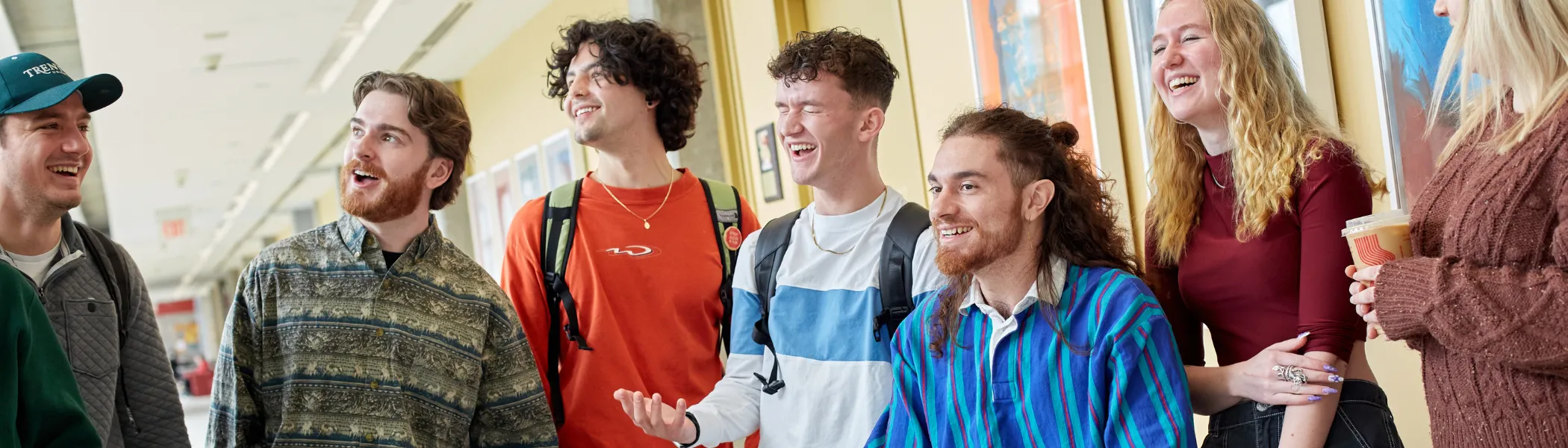 Trent University students talking and laughing with each other in a hallway.