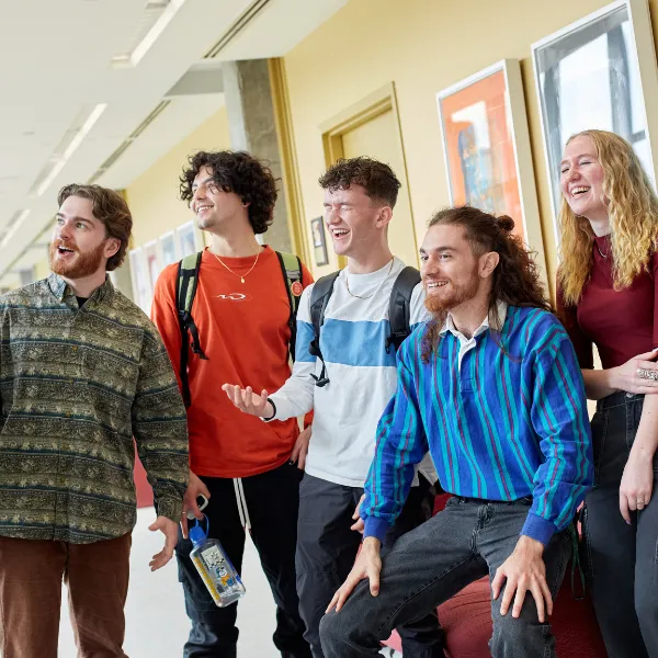 Trent University students talking and laughing with each other in a hallway.