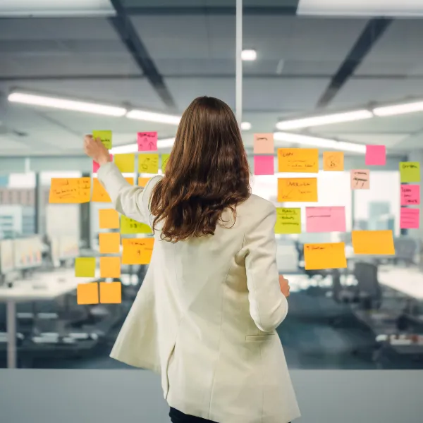 Business person creating marketing project plan on Office window with Paper Notes. 