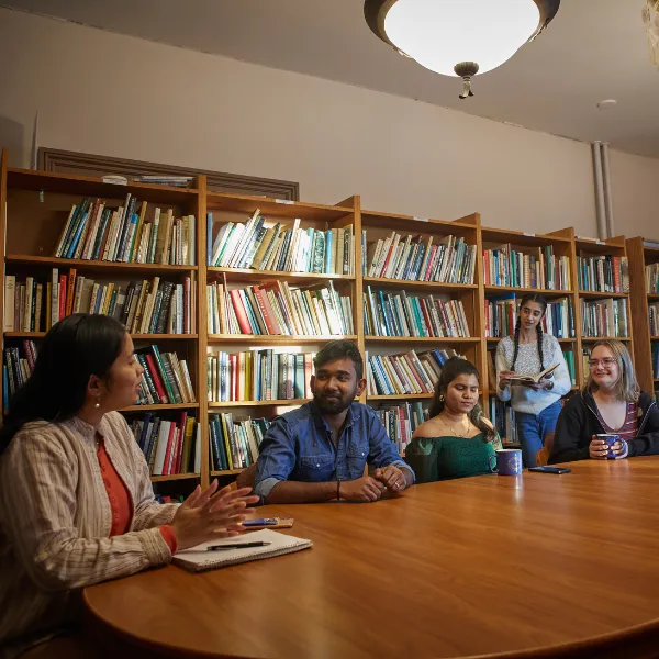 Trent University students talking in seminar room in Kerr house.