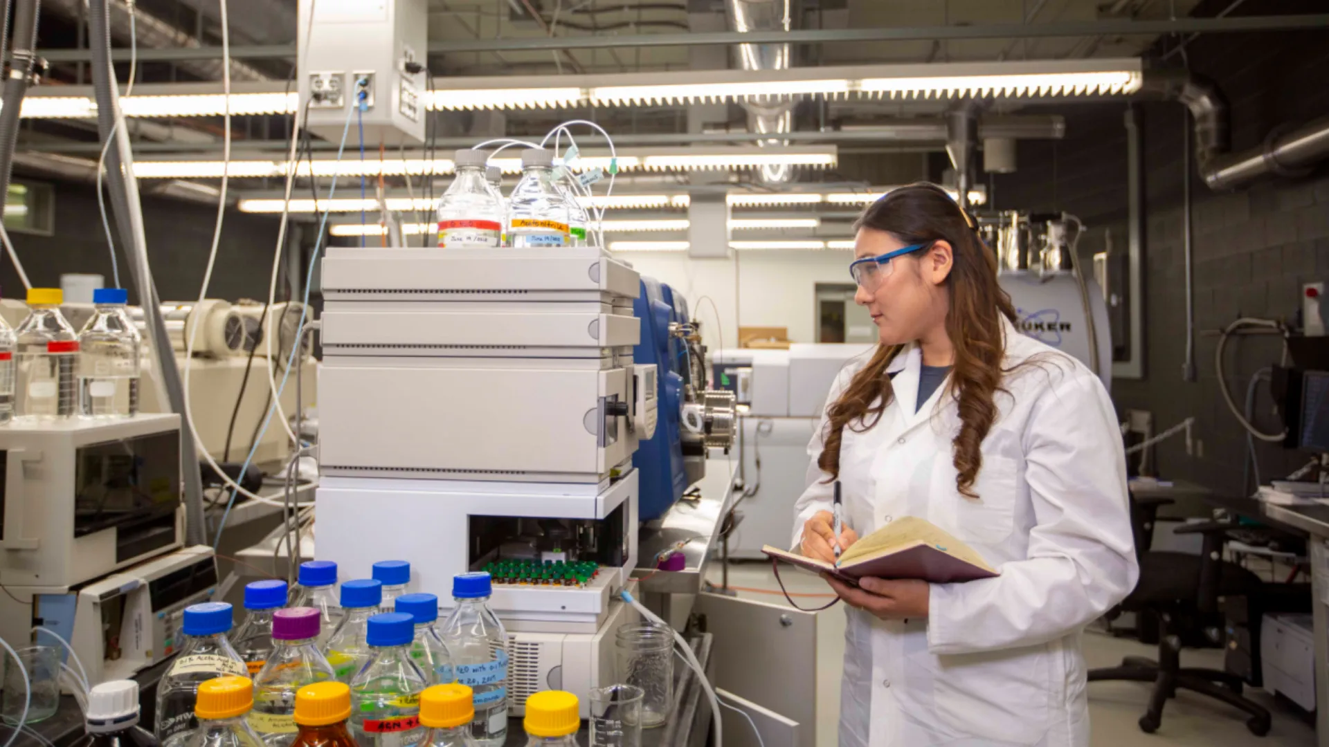 A student takes notes while a machine is running