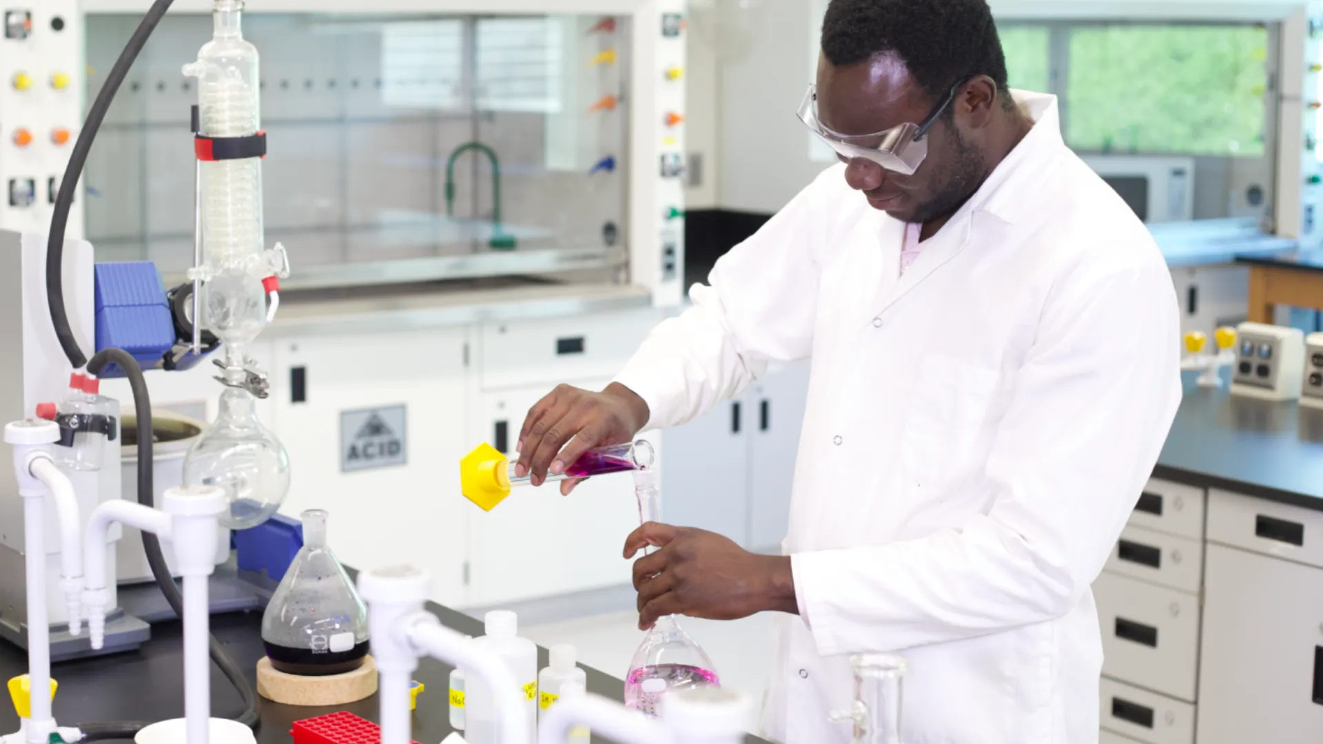A student pours a solution in a lab