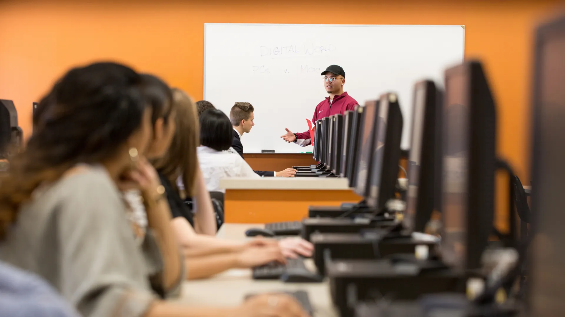 Students in a computer lab listening to the instructor