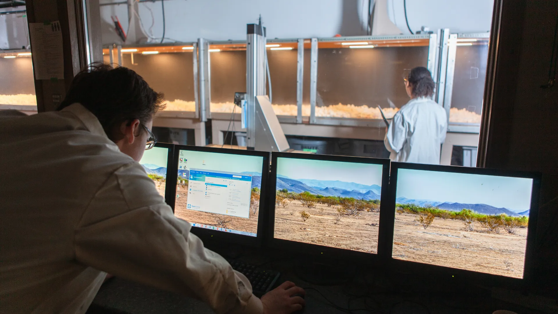 A student examines information on a screen while another examines a scientific instrument