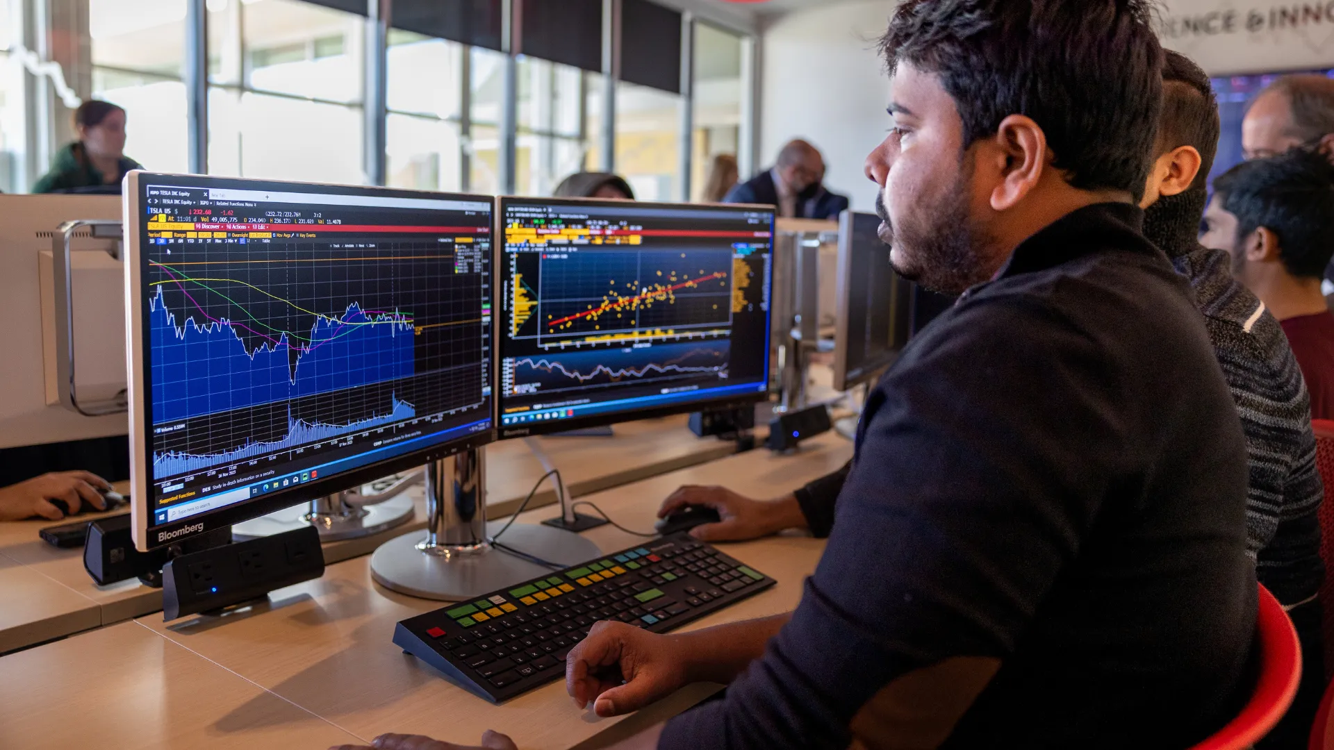 Trent student examines stock financial graphs on a computer screen