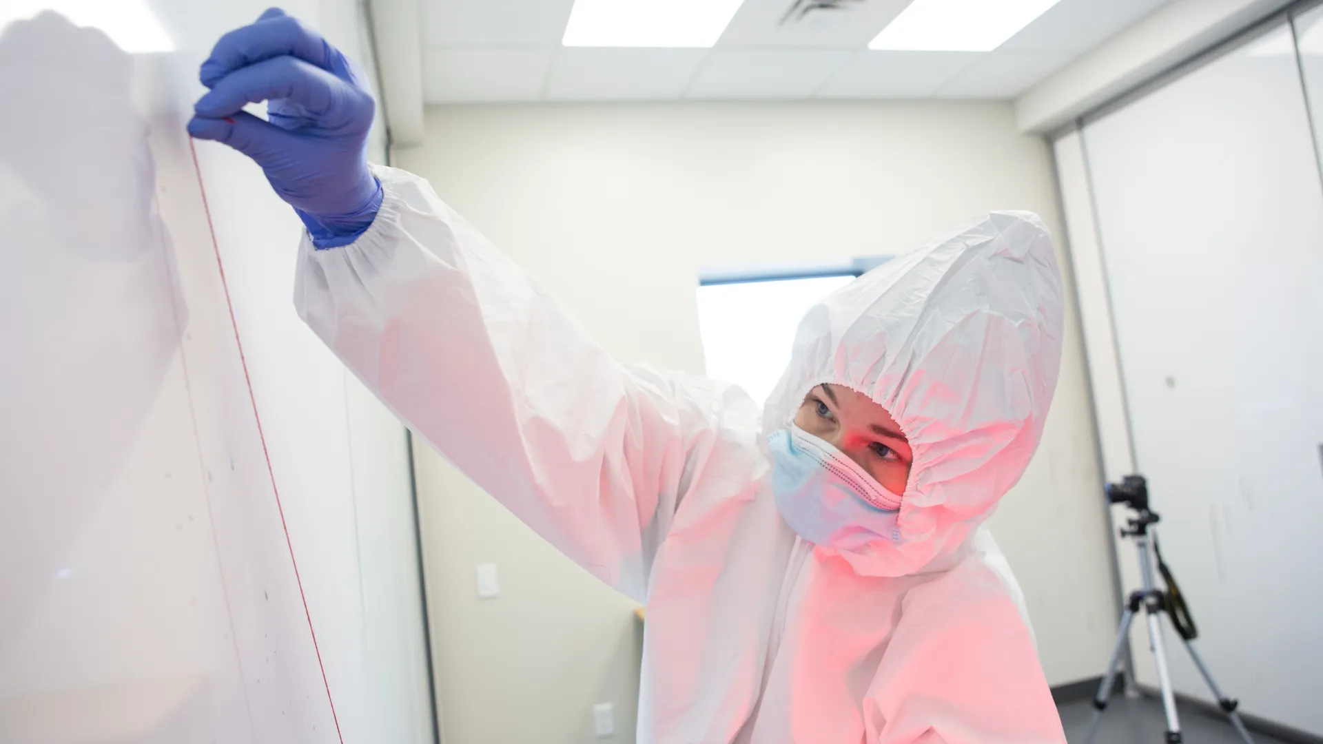 A forensic science student takes measurements in the Forensic Crime Scene Facility