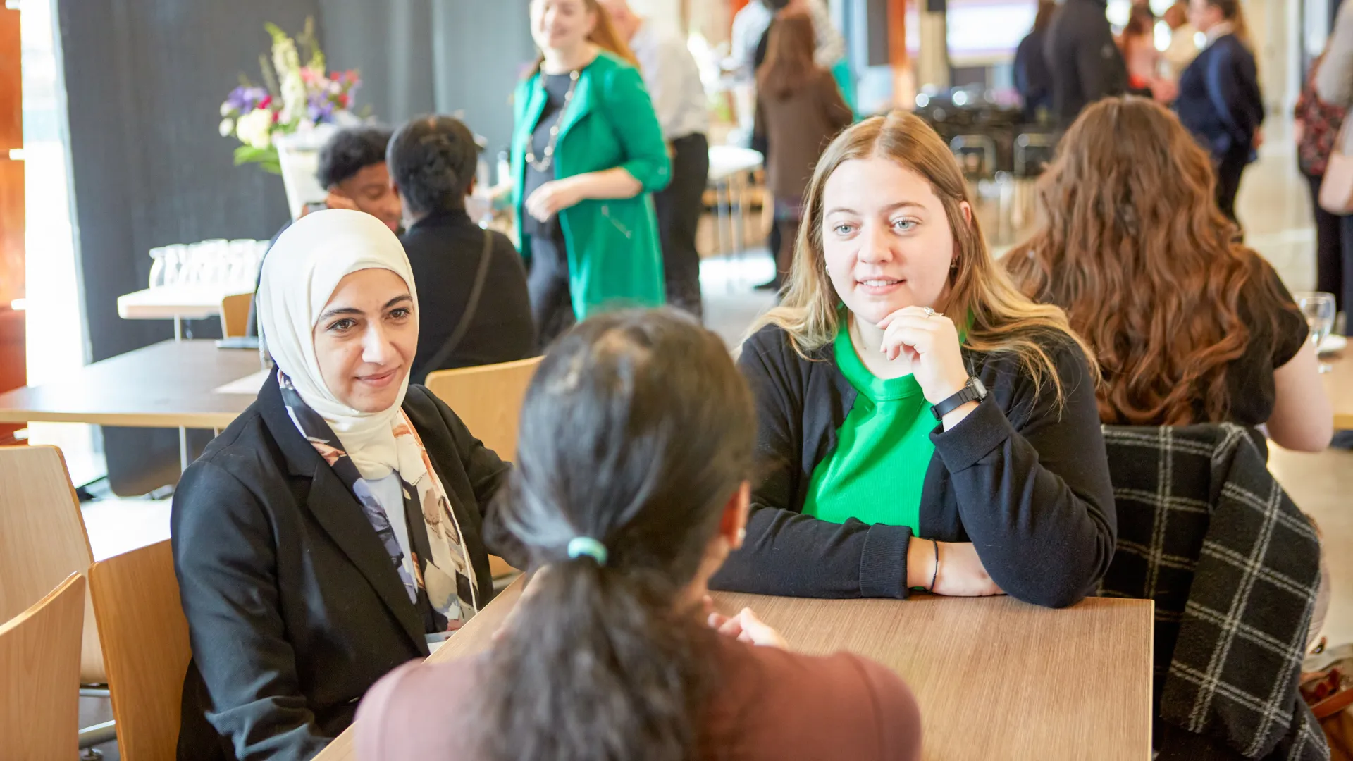 Trent students sit around a table discussing course materials in a common area