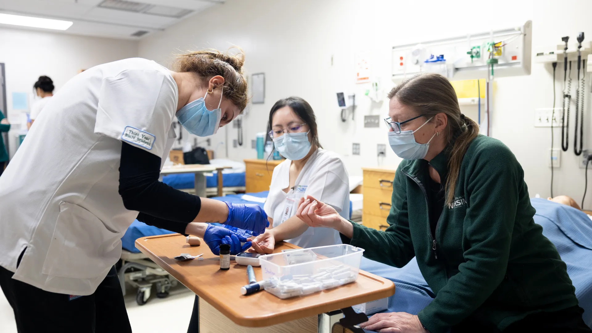 Nursing students practice taking blood sugar readings