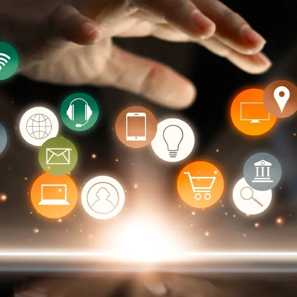 A person waving their hand over a tablet with floating icons