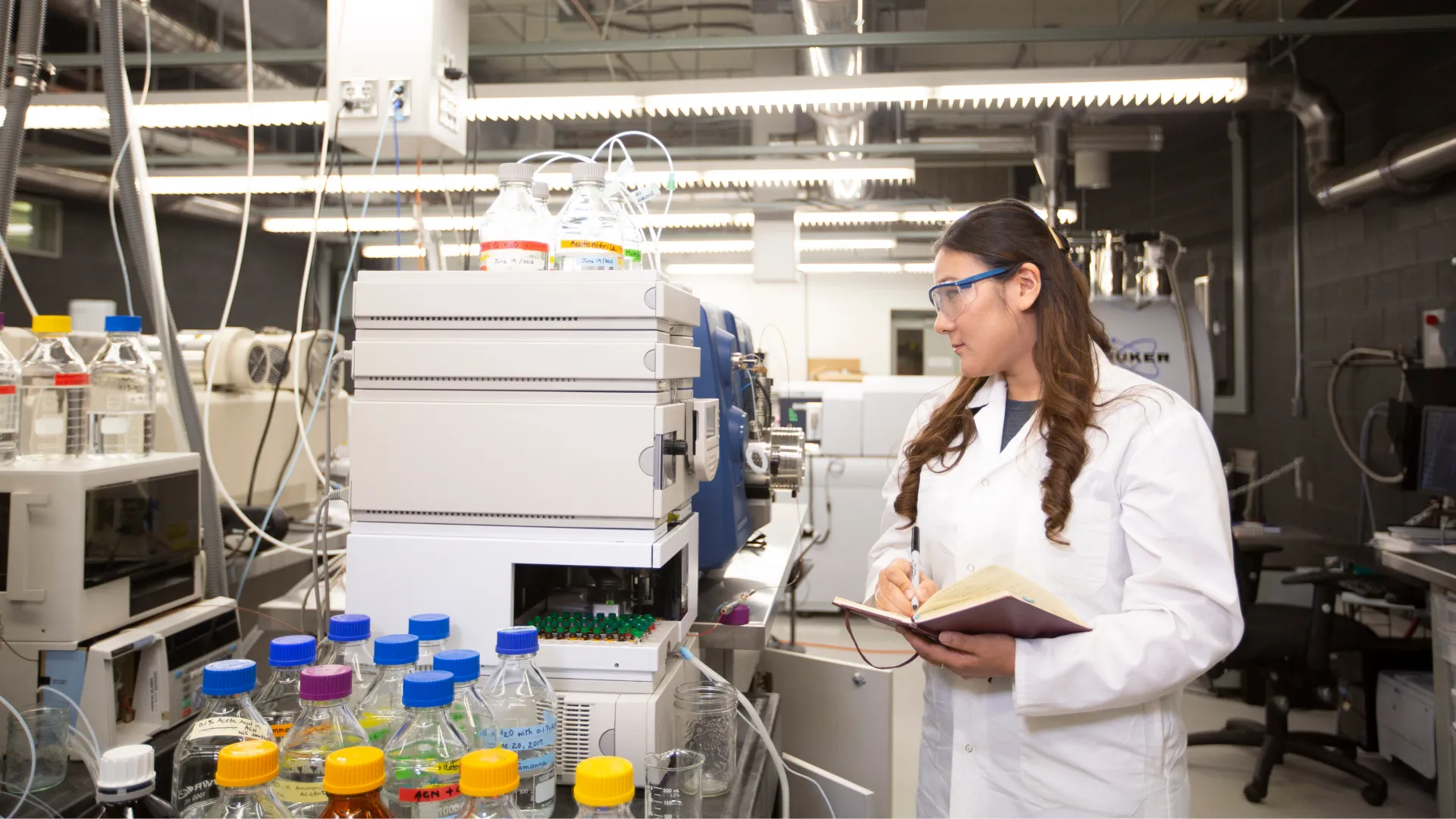Student in lab, looking at equipment.