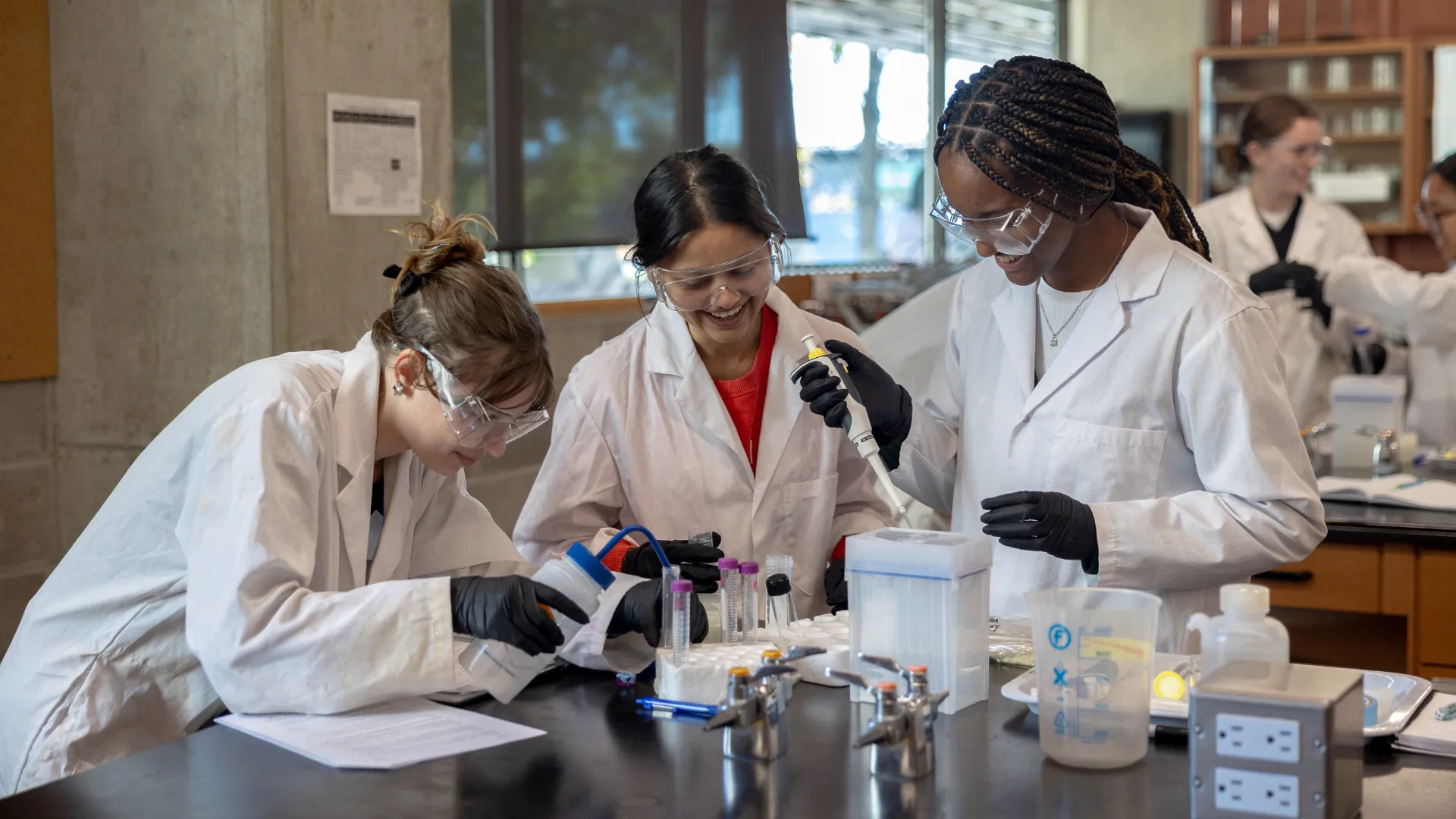 Students in labs using pipettes.