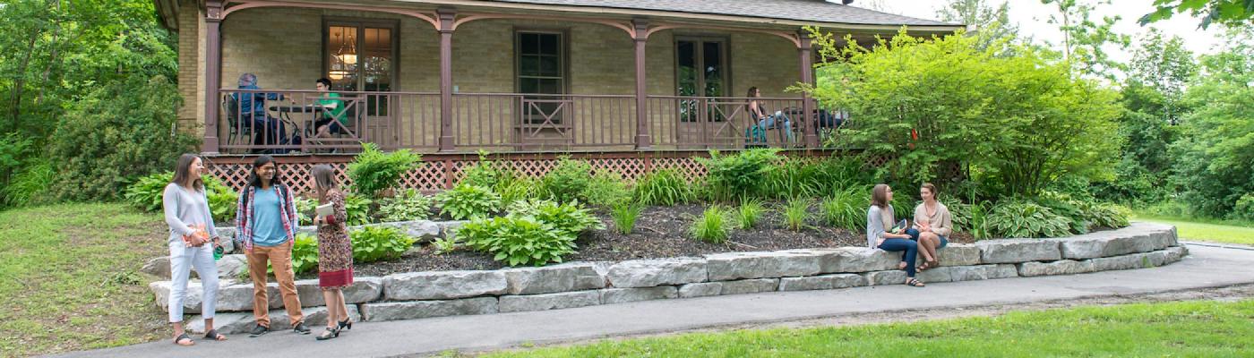 A house with people in the foreground talking to each other