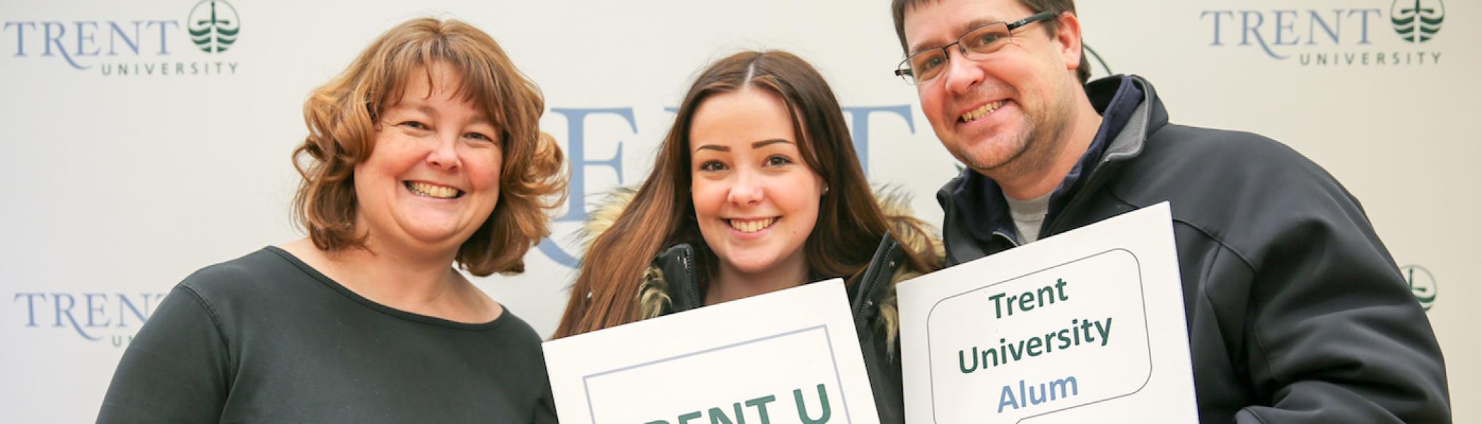 A girl standing between her parents at Trent University