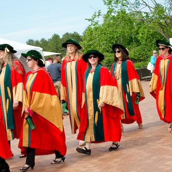 A group of graduate students walking in a line on convocation