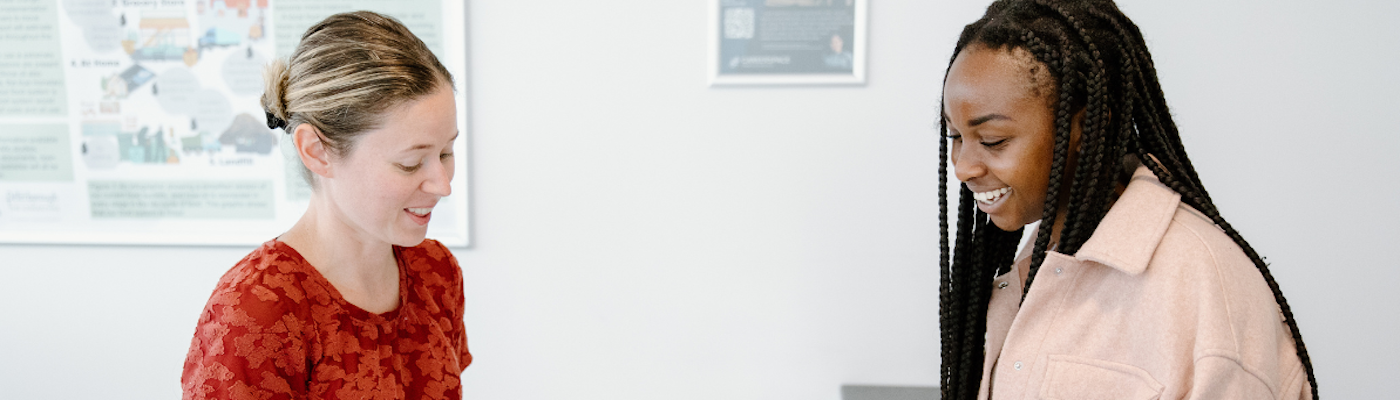 Two woman at counter, one staff, offering support to student