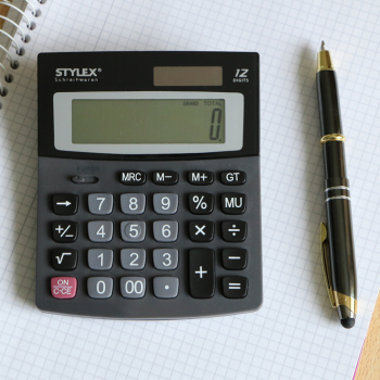 A calculator and pen on top of graph paper