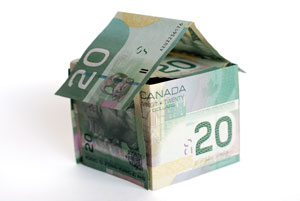 Canadian bills stacked in the shape of a house. 