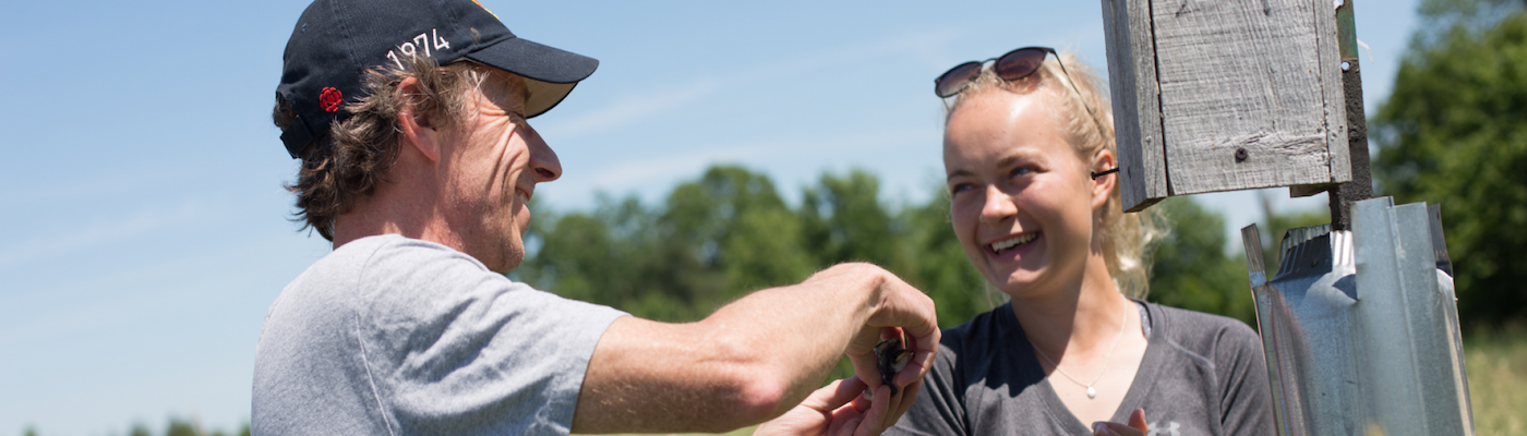 Professor and student outside smiling 