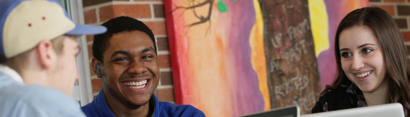 Three students sitting together on a laptop