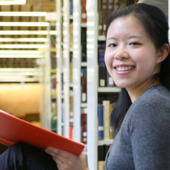 Student sitting in library looking at camera