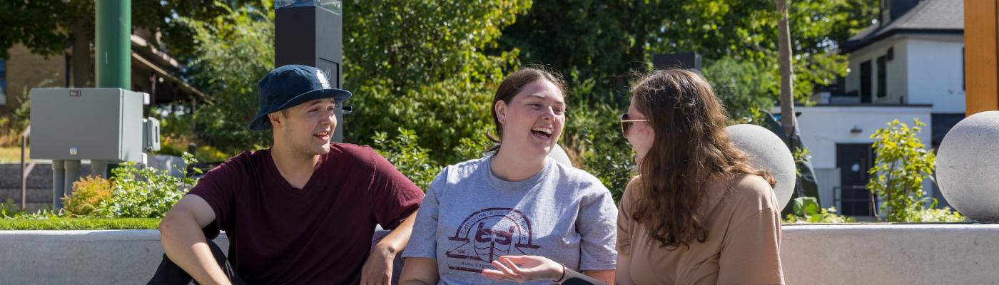 Three students conversing in the Jalynn Bennett Amphitheatre