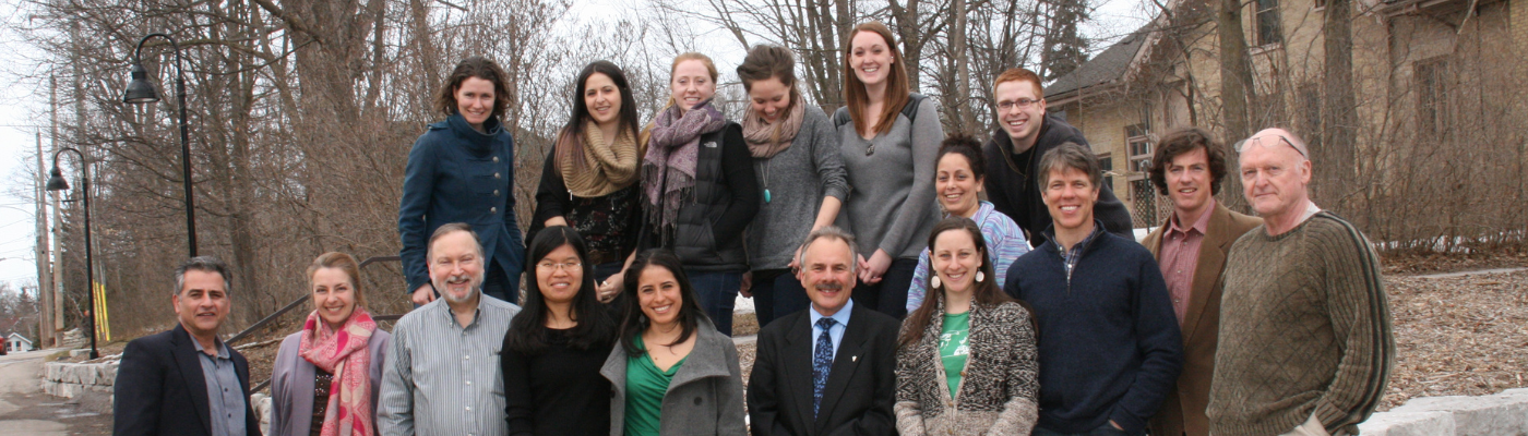 class photo with 2014 cohort and professors standing outside traill college