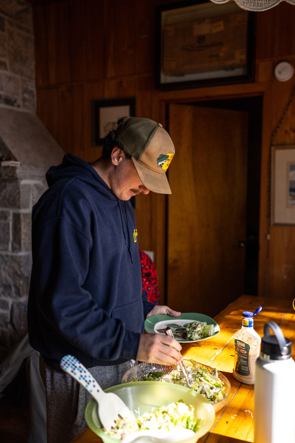 male student getting salad on his plate
