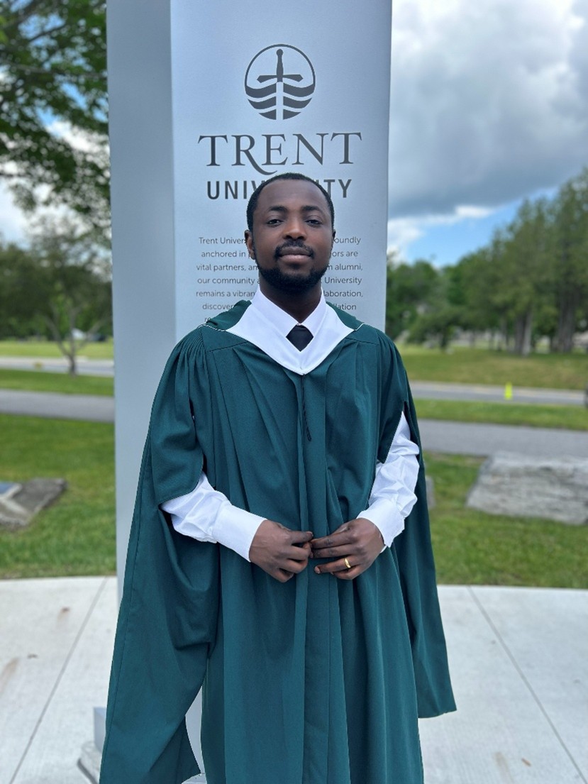 graduate of sustainability studies, samuel afutor, in graduation gown smiling at camera