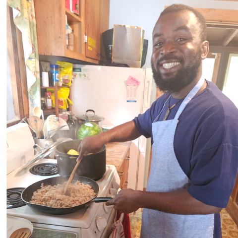 smiling male student cooking food