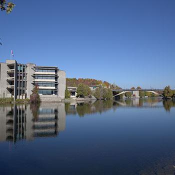 Photo of Bata Library, Otonabee River, and the Fayron Bridge from the East Bank.