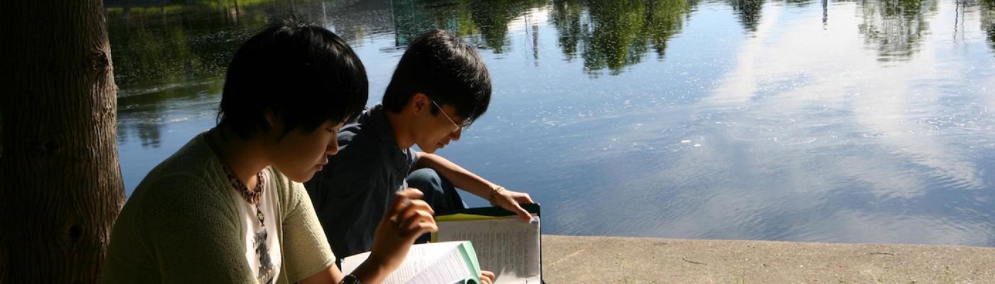 Students studying by the river