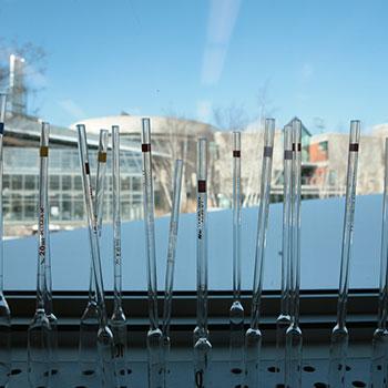 Pipettes standing up against a window with a snow-covered east bank in the background.