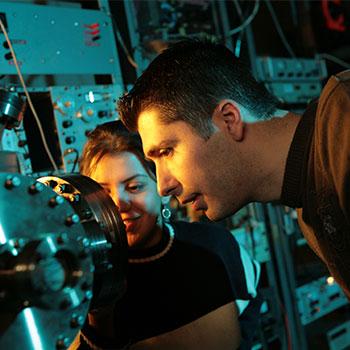 Two researchers studying an instrument at the Trent Centre for Materials Research