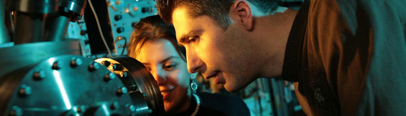 Two researchers studying an instrument at the Trent Centre for Materials Research
