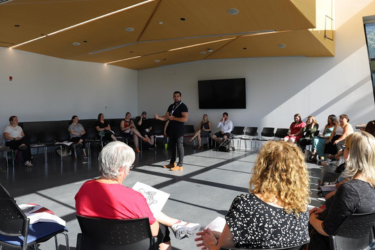 Mitch delivering a lecture to a room of people