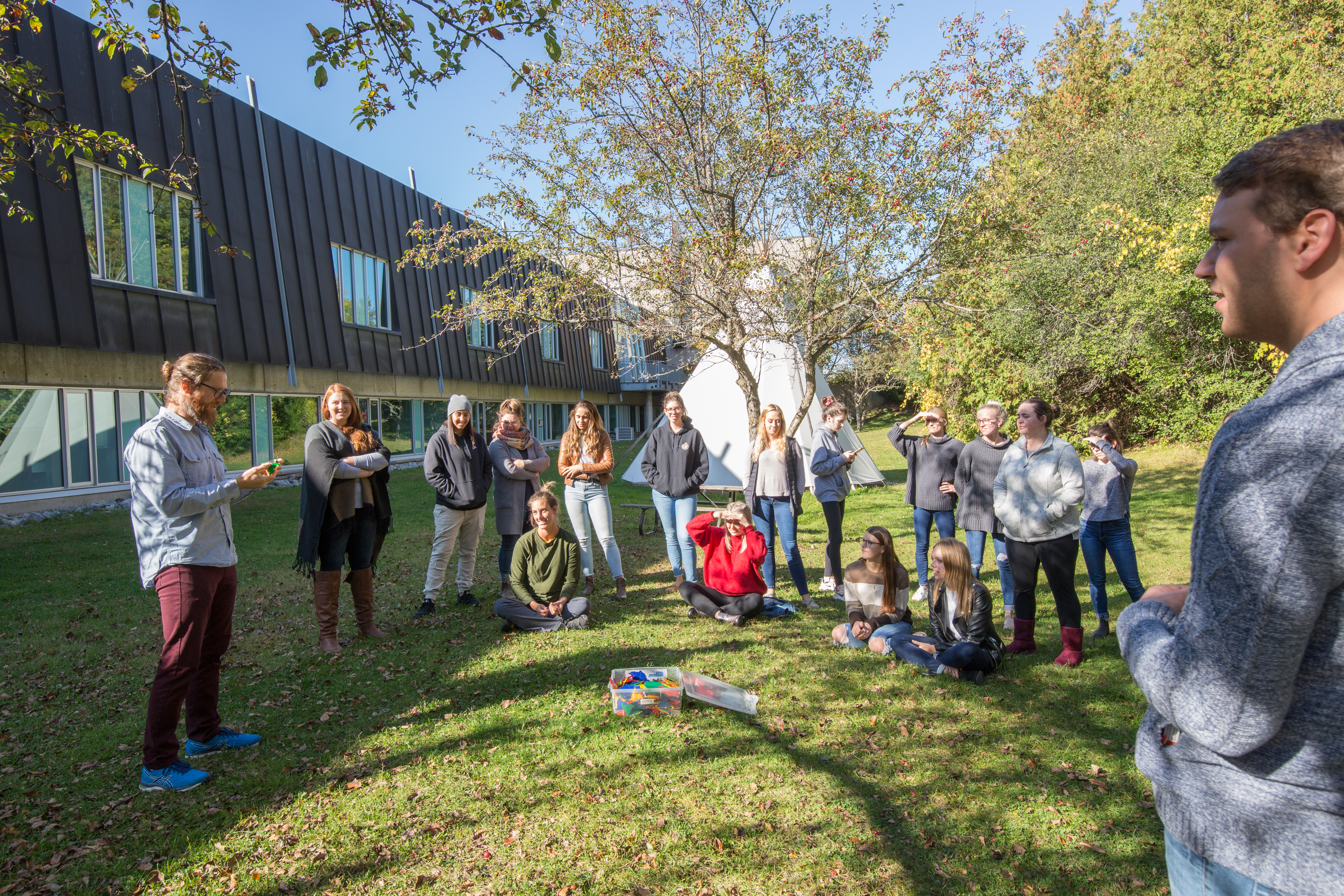 Students and prof having class outside.