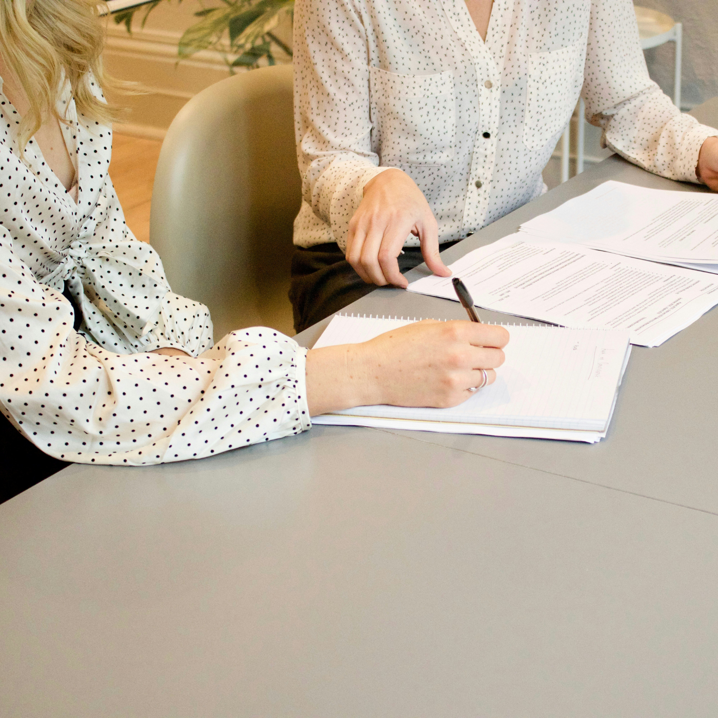 two people sitting at a table with papers in front of them