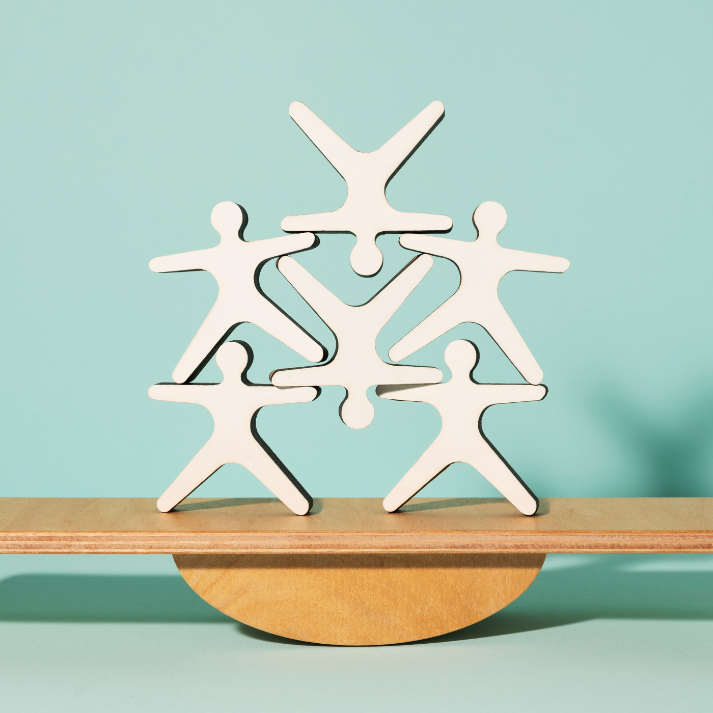 stick figures balancing on a board
