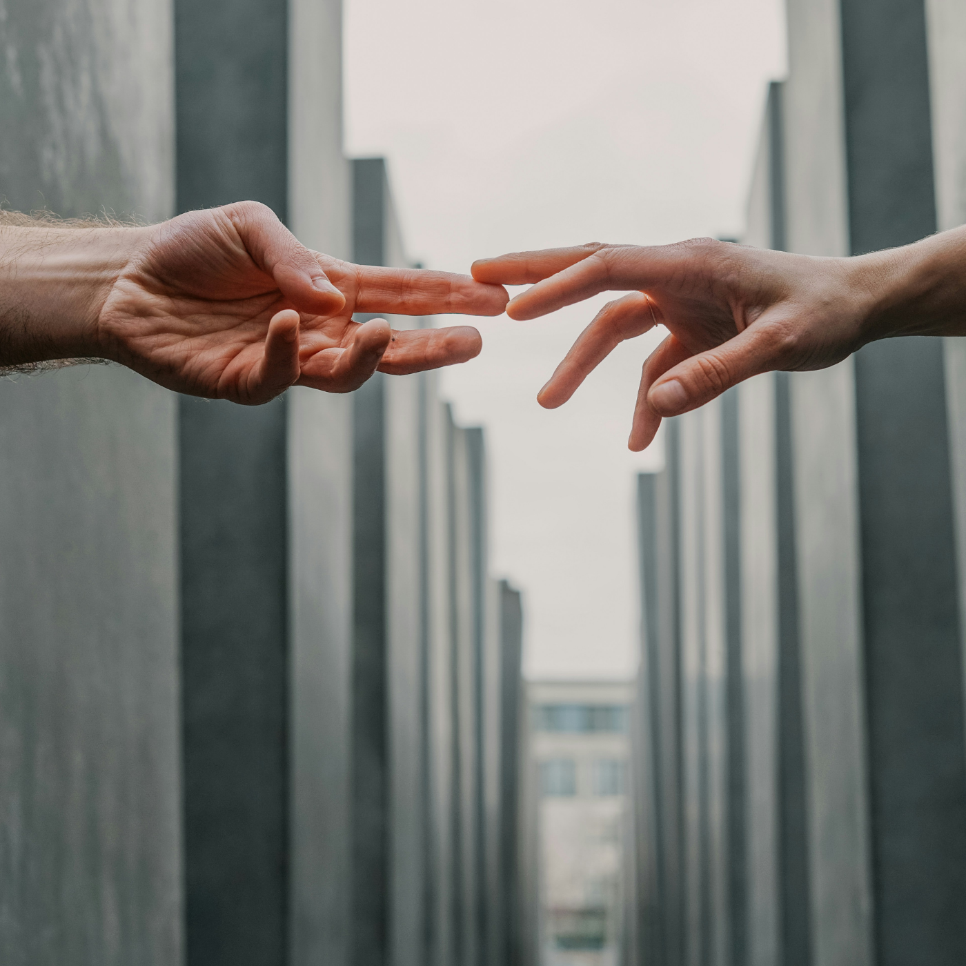 hands reaching for each other across grey background