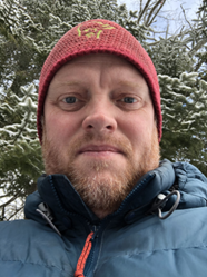 "Pat Maher selfie in front of a snowy forest"