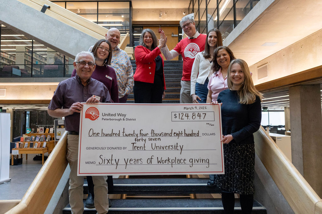 Trent University team members stand with United Way Peterborough representatives holding a large cheque for $124,847 during a campaign celebration on March 9, 2026