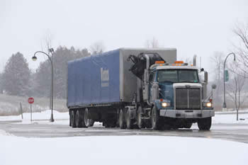 A large blue truck entering the Trent Symon's campus. 