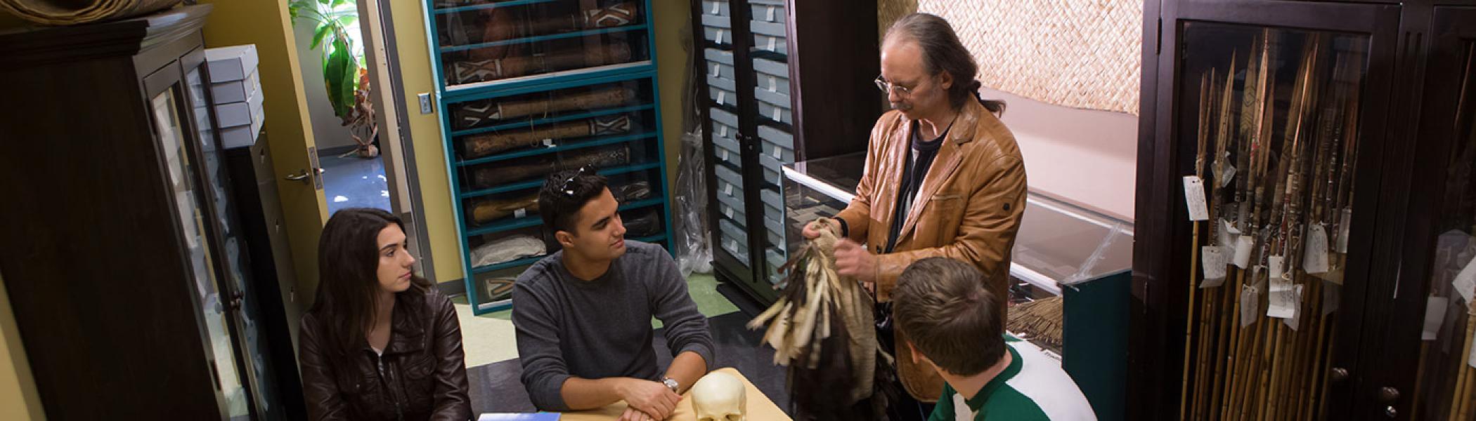Professor showing students some artifacts in a classroom.